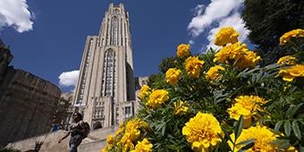 student walking in front of Cathedral of Learning
